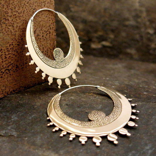 Crescent-shaped hoop earrings in Italian brass with textured detailing and sterling silver hooks.
